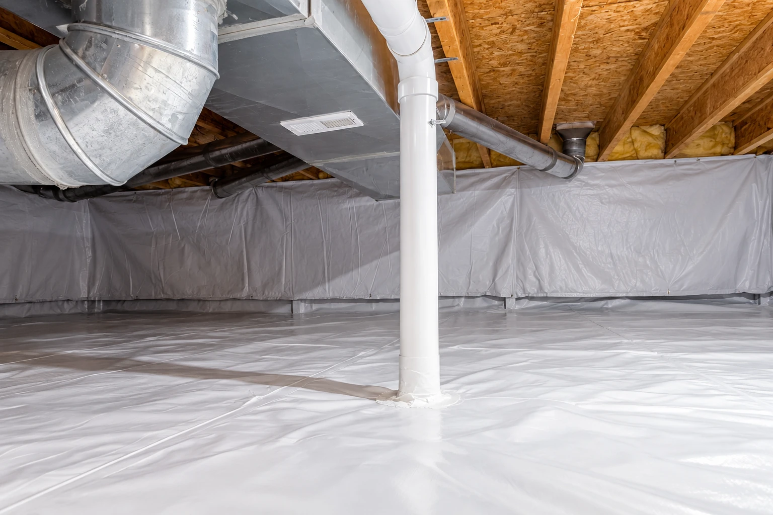 A crawl space has a white plastic vapor barrier across the floor and walls, with ducts and a pipe overhead.